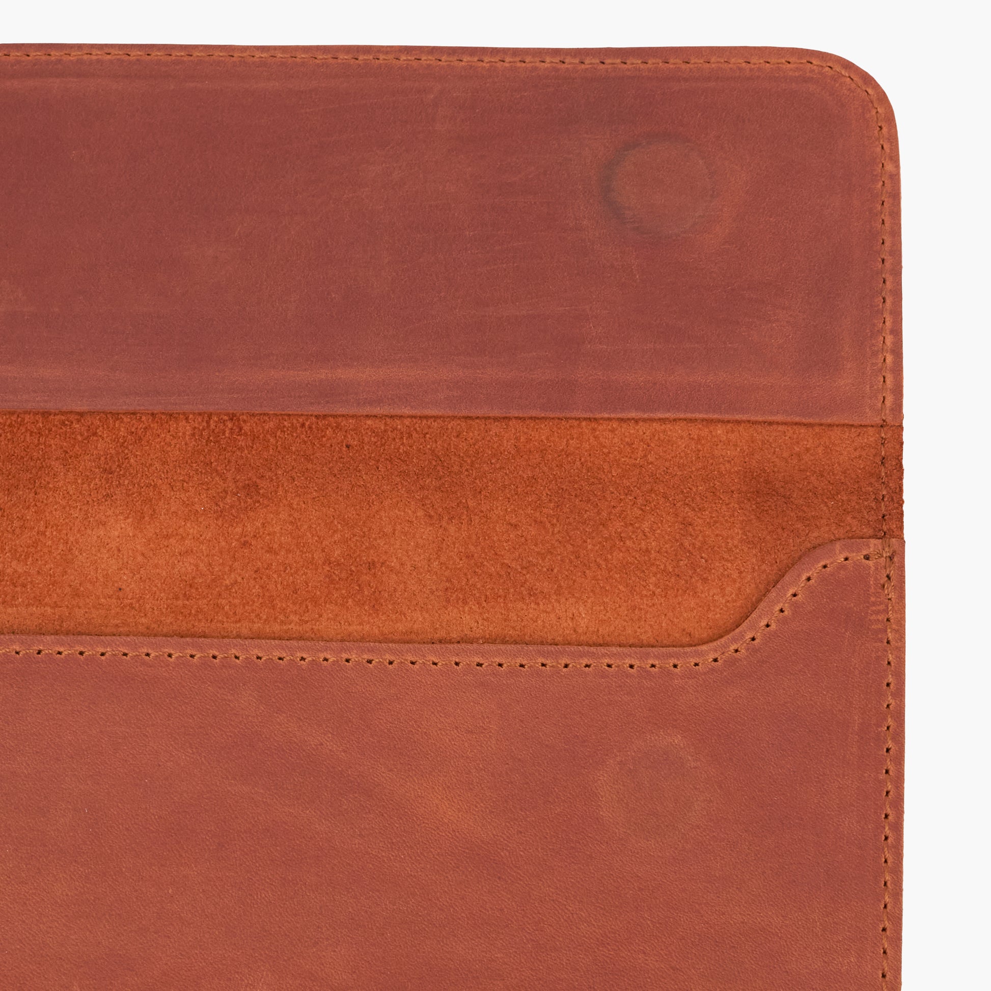 Close-up of open cognac Crazy Horse leather MacBook sleeve showing interior, stitching and magnetic closure