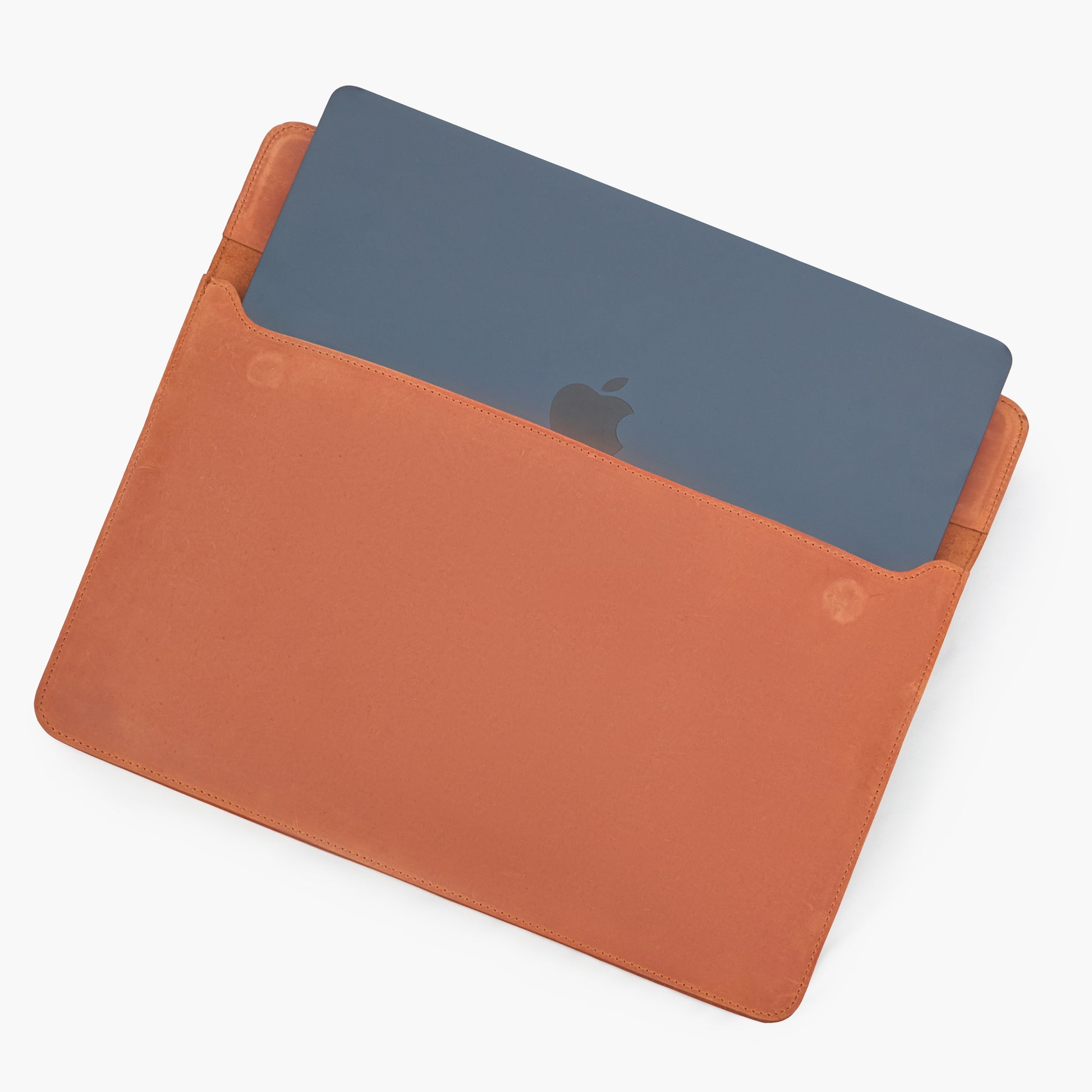 Cognac Crazy Horse leather MacBook sleeve with partially inserted MacBook